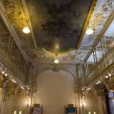 Siamo nel foyer: non appena vi mettiamo piede non possiamo fare a meno di sentirci catapultati indietro nel tempo. Il bianco e l�oro avvolgono completamente la sala che lascia sbalorditi e incantati per maestosit� e bellezza, con elaborate decorazioni floreali e stucchi che catturano gli occhi del visitatore